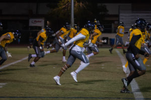 Phoenix College runs through their warm ups before their final home game against the Scottsdale Artichokes. The Bears have been playing football for decades, and won a junior college national championship in 1964. (Photo by Sarah Farrell)