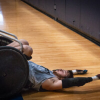 Ben Goss has suffered from shoulder issues ever since the accident. In the middle of practice he gets tipped backward toward the floor where he can stretch his shoulder to relieve himself from some pain. He told us that regardless of how much he warms up before a game, it isn't until the end of the game when his shoulder finally starts to feel comfortable. (Photo by Olivia Steinfeld)